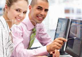 Businessman and woman working on computers