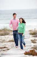 Couple running along beach path