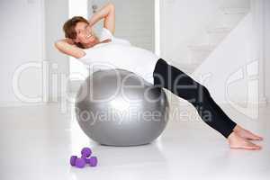 Senior woman using gym ball