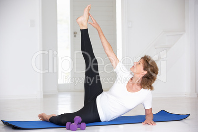 Senior woman exercising in home gym