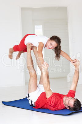 Father and daughter doing yoga lift
