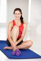 Woman sitting on exercise mat