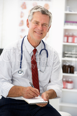Senior doctor writing prescription