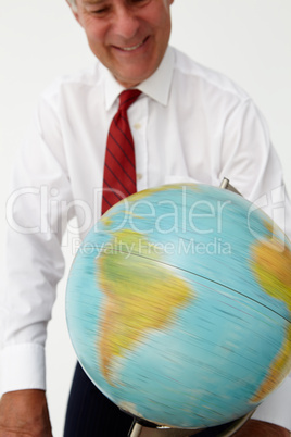 Senior businessman spinning globe