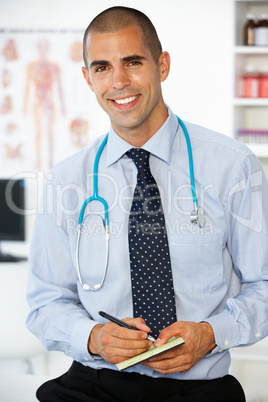 Young male doctor writing prescription
