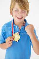 Young boy showing off medal