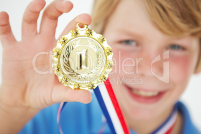 Young boy showing off medal