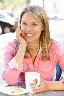 Woman sitting at sidewalk café