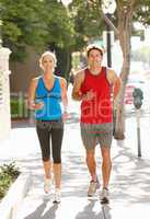 Couple running on city street