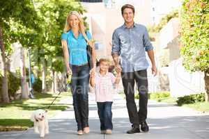 Family walking with dog in city street