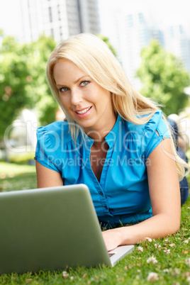 Woman using laptop in city park