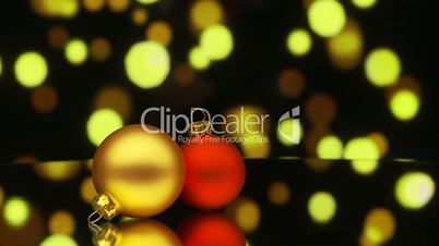 two christmas baubles rotating with bokeh