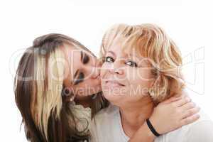Closeup of young girl kissing her mom isolated on a white backgr