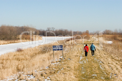 People Walking Hiking Trail Through Frozen Marsh