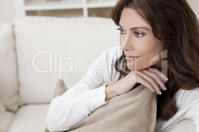 Brunette Woman Sitting Thinking At Home on Sofa