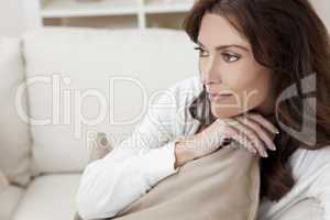 Brunette Woman Sitting Thinking At Home on Sofa
