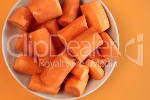 Fresh chopped carrots on an orange background