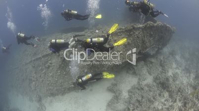 scuba divers above shipwreck