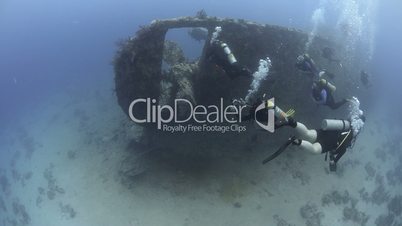 scuba divers exploring the stern of a shipwreck