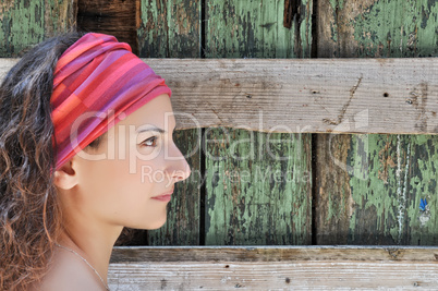 Beautiful woman stands in front of wooden wall