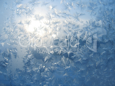 Ice pattern and sunlight on winter glass