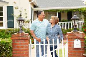 Senior Hispanic couple outside home