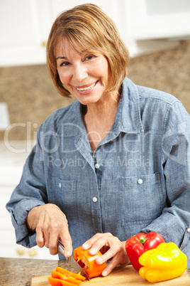 Mid age woman chopping vegetables