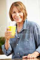 Mid age woman drinking orange juice