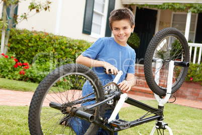 boy fixing bike in garden