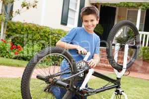 boy fixing bike in garden