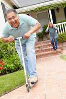 Senior couple playing with children's scooter