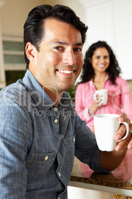 Hispanic couple relaxing in kitchen