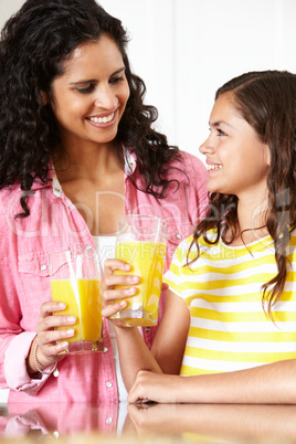 Mother and daughter drinking orange juice