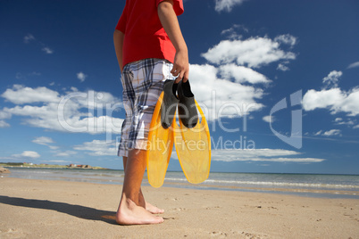 Teenage boy on beach with flippers