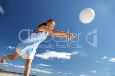 Teenage girl playing beach volleyball