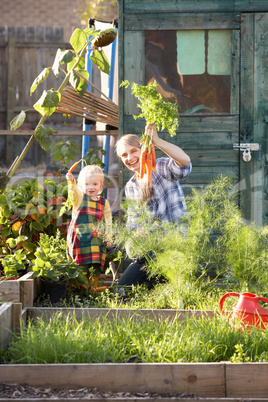 Woman working on allotment with child