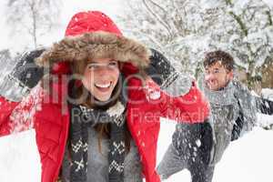 Young couple having snowball fight