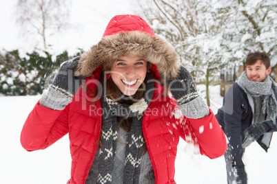 Young couple having snowball fight