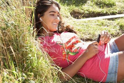 Teenage girl using mp3 player outdoors