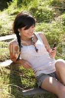 Teenage girl using mp3 player outdoors