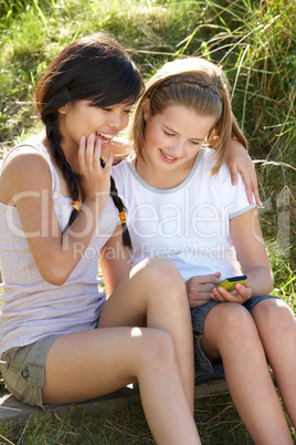 Teenage girls using phone outdoors