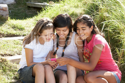 Teenage girls using phone outdoors