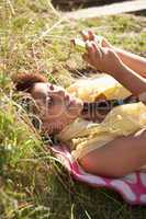 Teenage girl lying on grass with phone