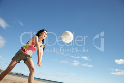 Teenage girl playing beach volleyball