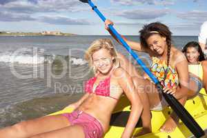 Teenage girls in sea with canoe