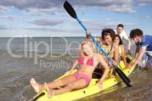 Teenagers in sea with canoe