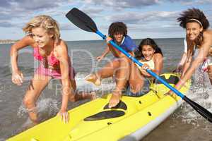 Teenagers in sea with canoe