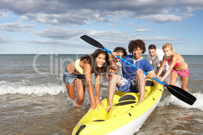 Teenagers in sea with canoe