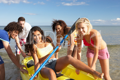 Teenagers in sea with canoe