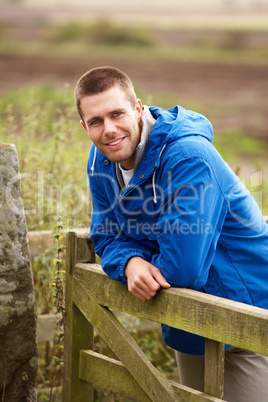Man leaning on country gate